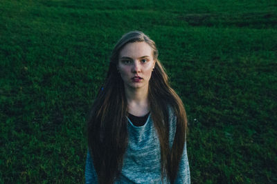 Portrait of beautiful young woman standing on field