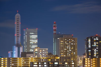 Illuminated buildings in city against sky at night