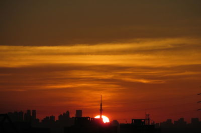 Silhouette of built structures against dramatic sky