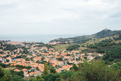 High angle view of townscape by sea against sky