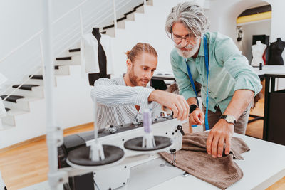 Male fashion designers working at boutique