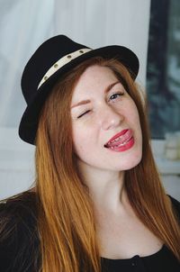 Close-up of smiling young woman sticking out tongue