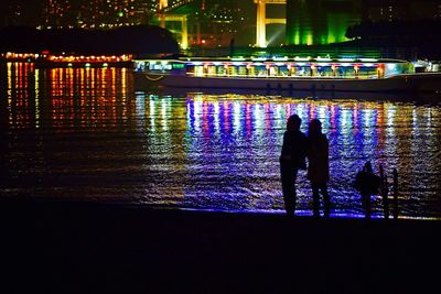People in illuminated city at night