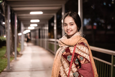 Portrait of a smiling young woman standing outdoors