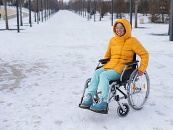 Low section of man riding bicycle on snow covered field