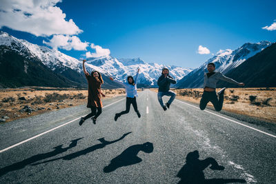 People on snowcapped mountain against sky