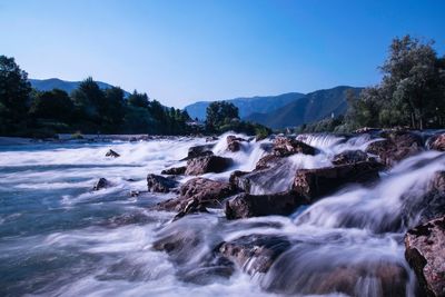 Scenic view of waterfall against sky