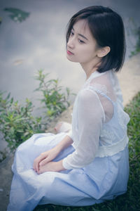 Woman looking away while sitting outdoors