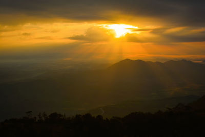 Scenic view of silhouette mountains against orange sky