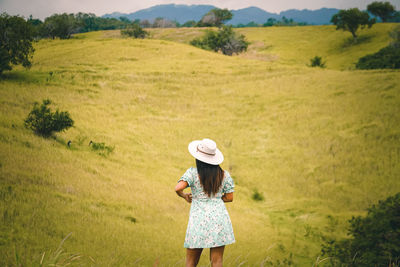 Rear view of woman standing on field