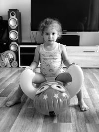 Cute girl sitting on hardwood floor at home