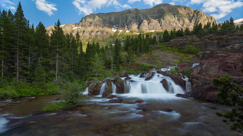 Stream flowing through rocks against mountain
