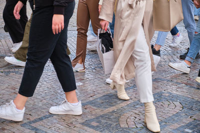 Low section of people walking on street