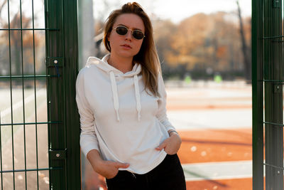 Portrait of young woman wearing sunglasses standing outdoors