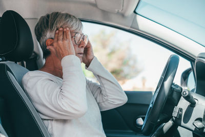 Portrait of senior woman sitting in car