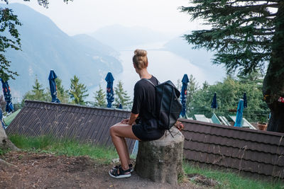 Woman sitting on bench looking at mountains
