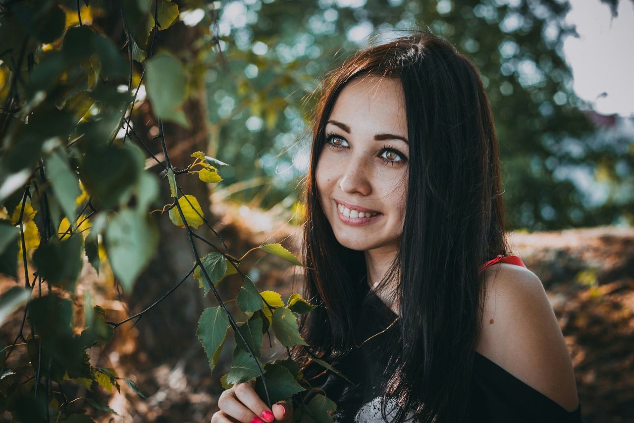 PORTRAIT OF YOUNG WOMAN IN PARK