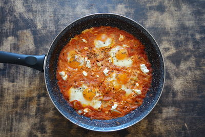 Shakshuka traditional dish on the wooden background, gastronomy