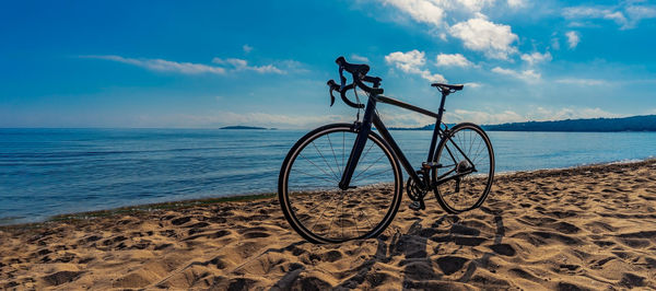 Bicycle on beach against sky