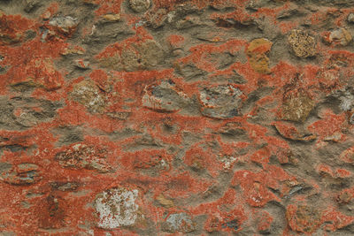 Horizontal stoned rock cobble stone wall red mortar for a textured background abstract material 