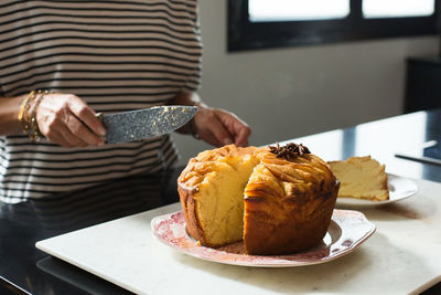 Young beautiful woman cutting homemade apple pie at the modern kitchen