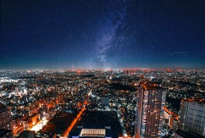 High angle view of illuminated city against sky at night