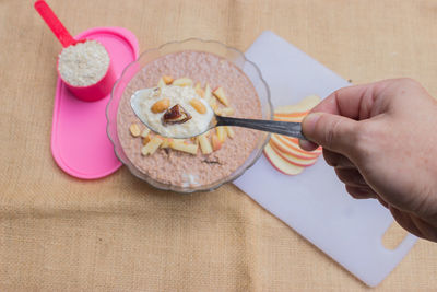 High angle view of hand holding food on table