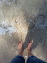 Low section of woman standing on beach