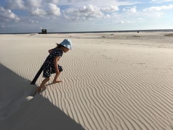 Side view of girl walking on sand at beach