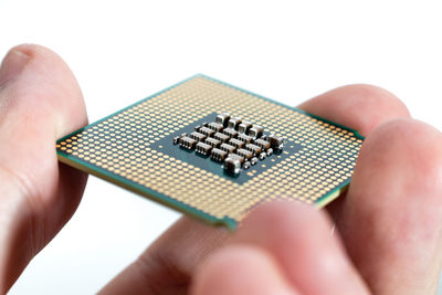 Midsection of person holding camera against white background