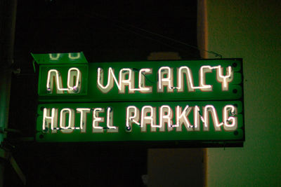 Low angle view of information sign at night