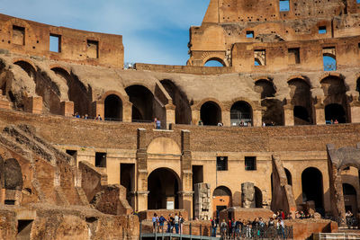 Tourists visiting the interior of the famous colosseum in rome