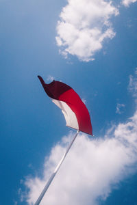 Low angle view of indonesian flag on pole against sky