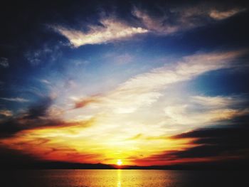 Scenic view of sea against dramatic sky during sunset