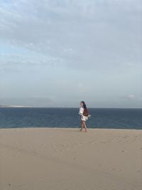 Woman on beach against sky