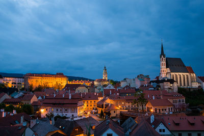 Buildings in town against cloudy sky