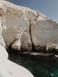 Rock formation in sea against sky