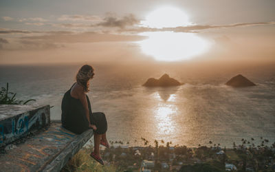 Man looking at sea against sky during sunset