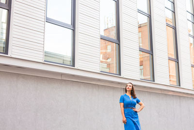 Portrait of woman standing against building