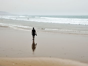 Man on beach against sky