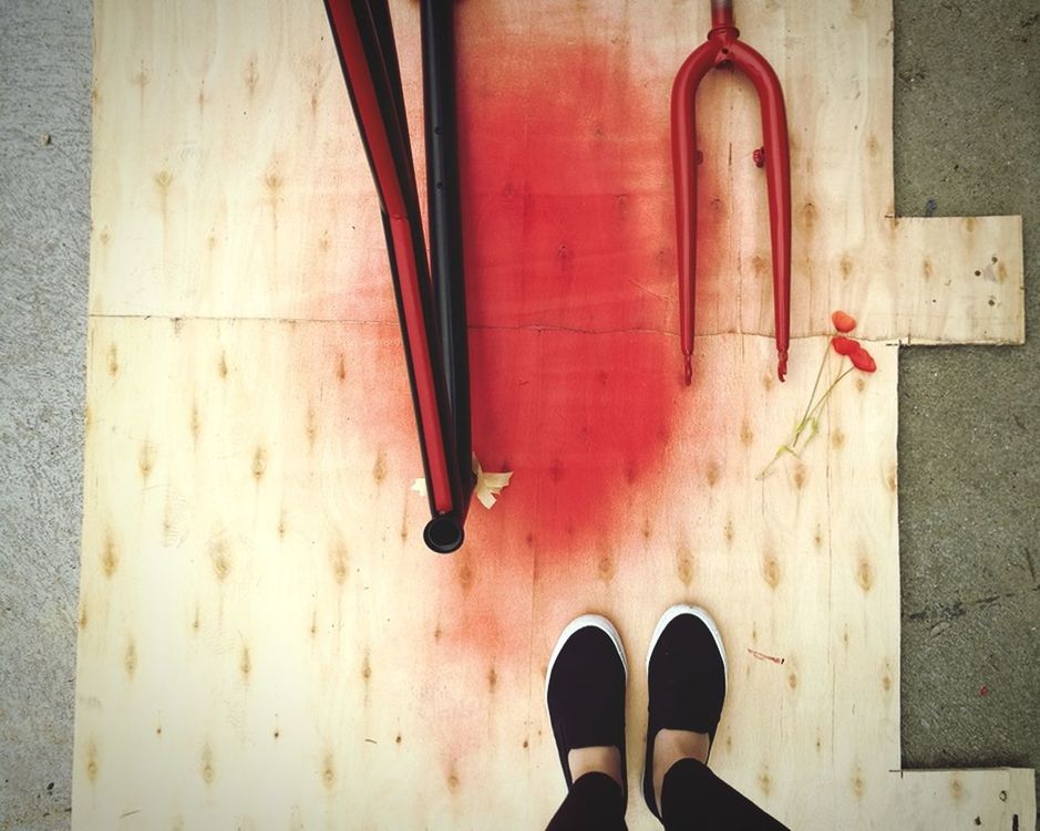 DIRECTLY ABOVE SHOT OF PERSON STANDING ON RED FLOOR