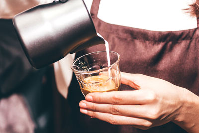 Close-up of hand pouring wine in glass