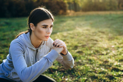 Young beautiful girl performs squats outdoors on a sunny day. close up.