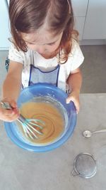 High angle view of girl eating bowl on table