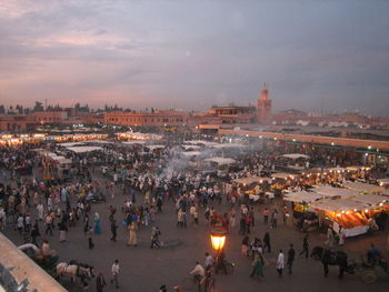 High angle view of people in illuminated city at dusk