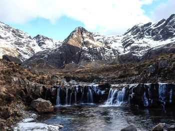 Scenic view of waterfall against sky during winter