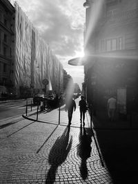 People walking on street amidst buildings in city