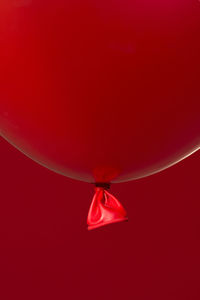 Low angle view of balloons against red background