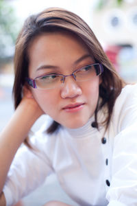 Close-up of thoughtful young woman wearing eyeglasses outdoors