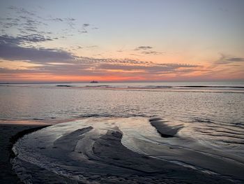 Scenic view of beach against sky during sunset